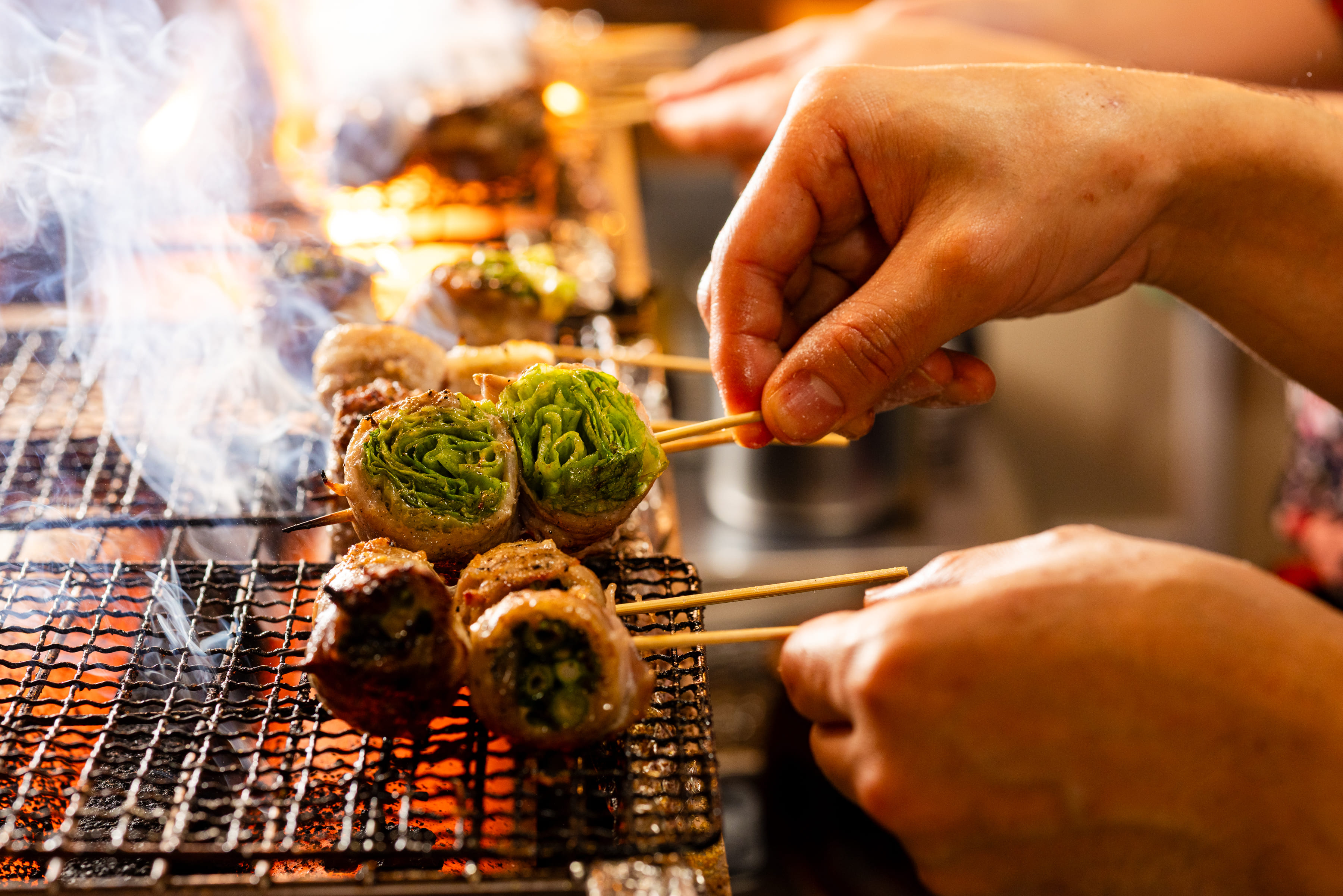炭火でじっくり焼かれる串と職人の手元